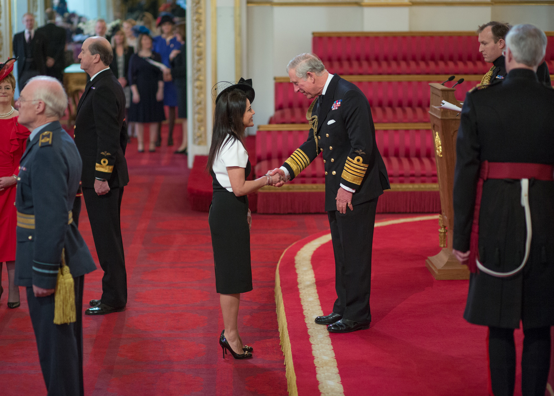 Kavita receiving her OBE from Prince Charles