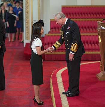 Kavita receiving her OBE from Prince Charles